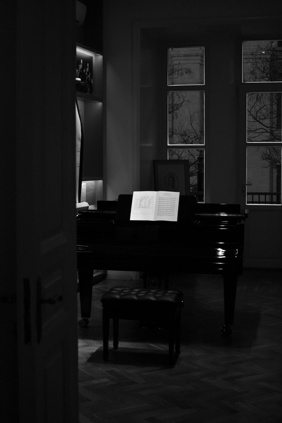 Piano de cola en una sala en penumbra